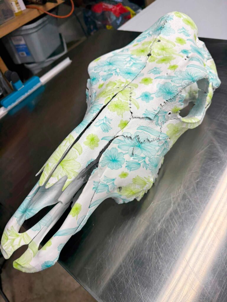 Animal skull finished in a teal and green floral hydrographic film